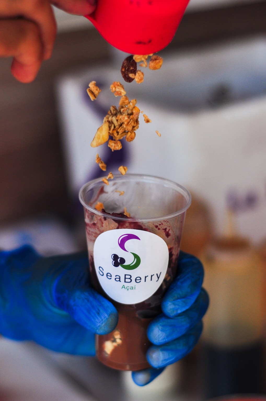 Granola pouring over a SeaBerry açaí bowl — best açaí in Madeira