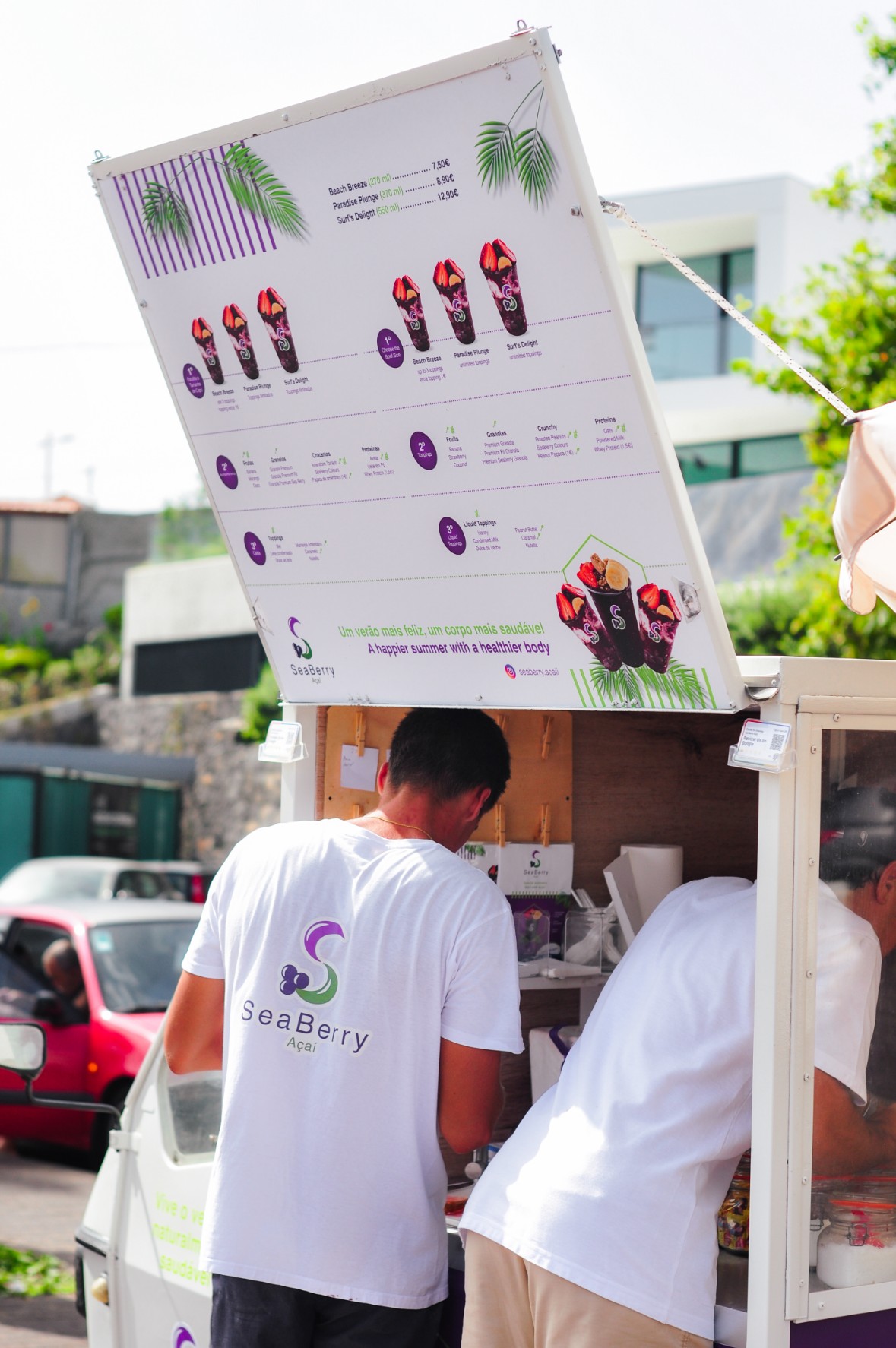 Two SeaBerry team members serving açaí at the beach
